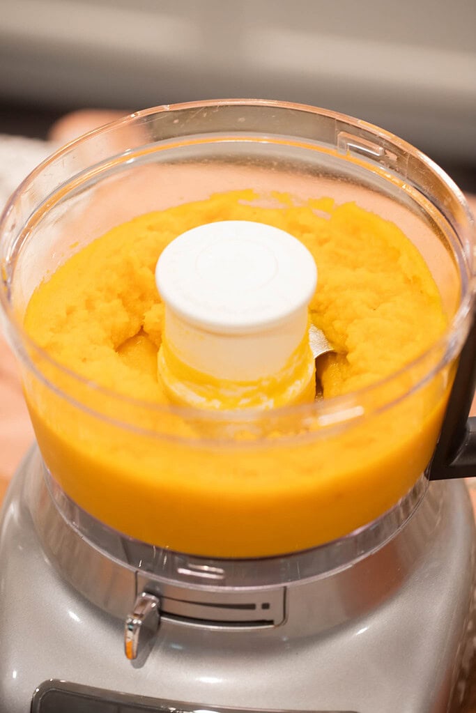 Blending roasted pumpkin into smooth puree in a food processor