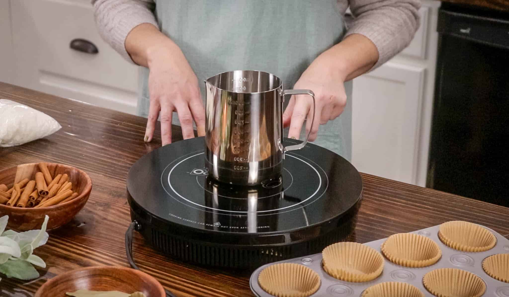 a candle melting pot on a hot plate in a cottage kitchen