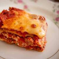 a slice of lasagna on a plate of china