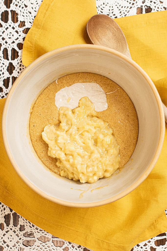 Mashed bananas and sourdough discard added to wet ingredients for sourdough banana muffin batter.