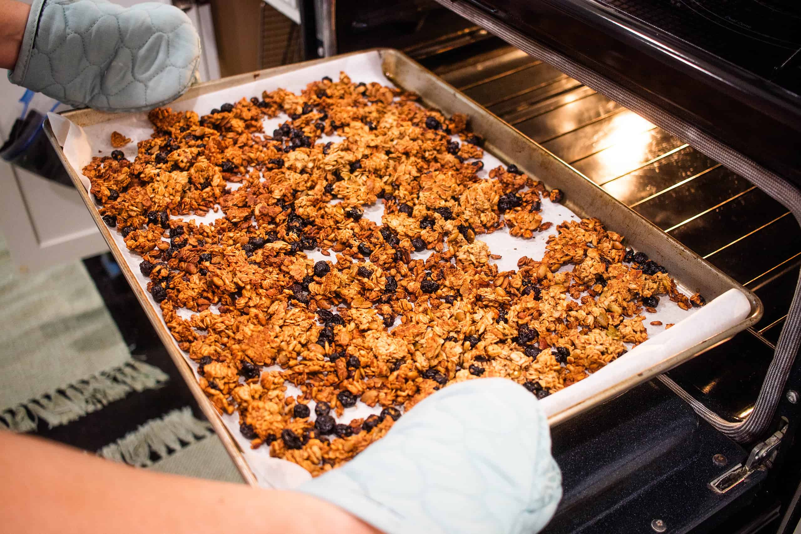 A cooked pan of sourdough discard granola coming fresh out of the oven in a cottage kitchen.