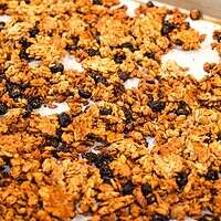 A pan of coked granola homemade in a cottage kitchen on a silver baking pan.