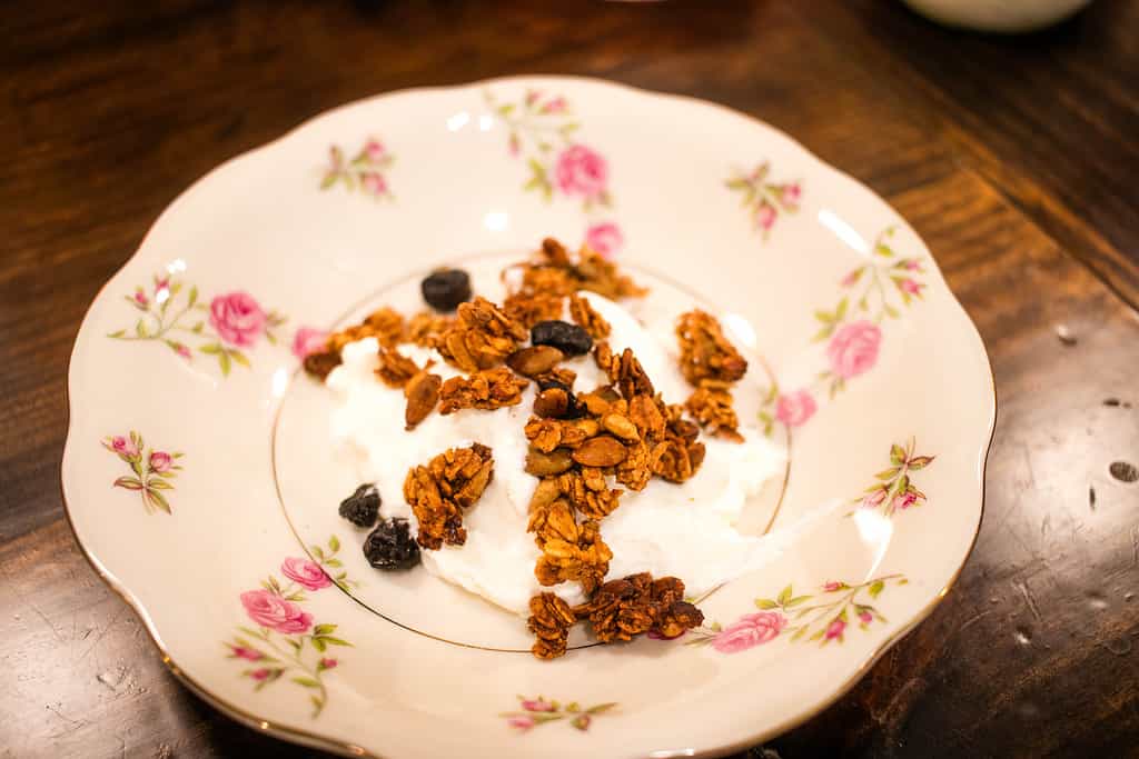 A bowl of yogurt and homemade granola in a cottage kitchen.
