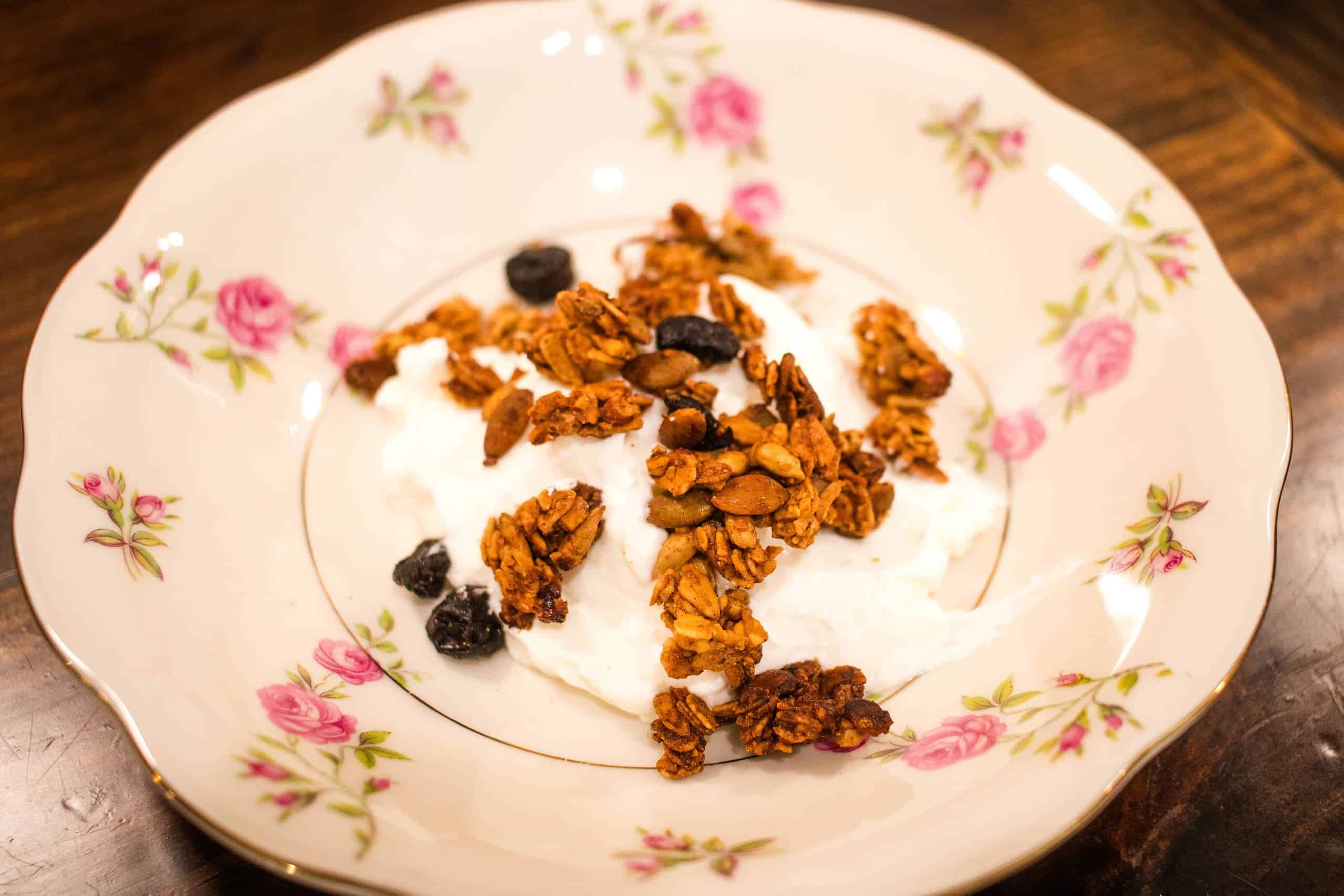 A bowl of yogurt and homemade granola in a cottage kitchen.