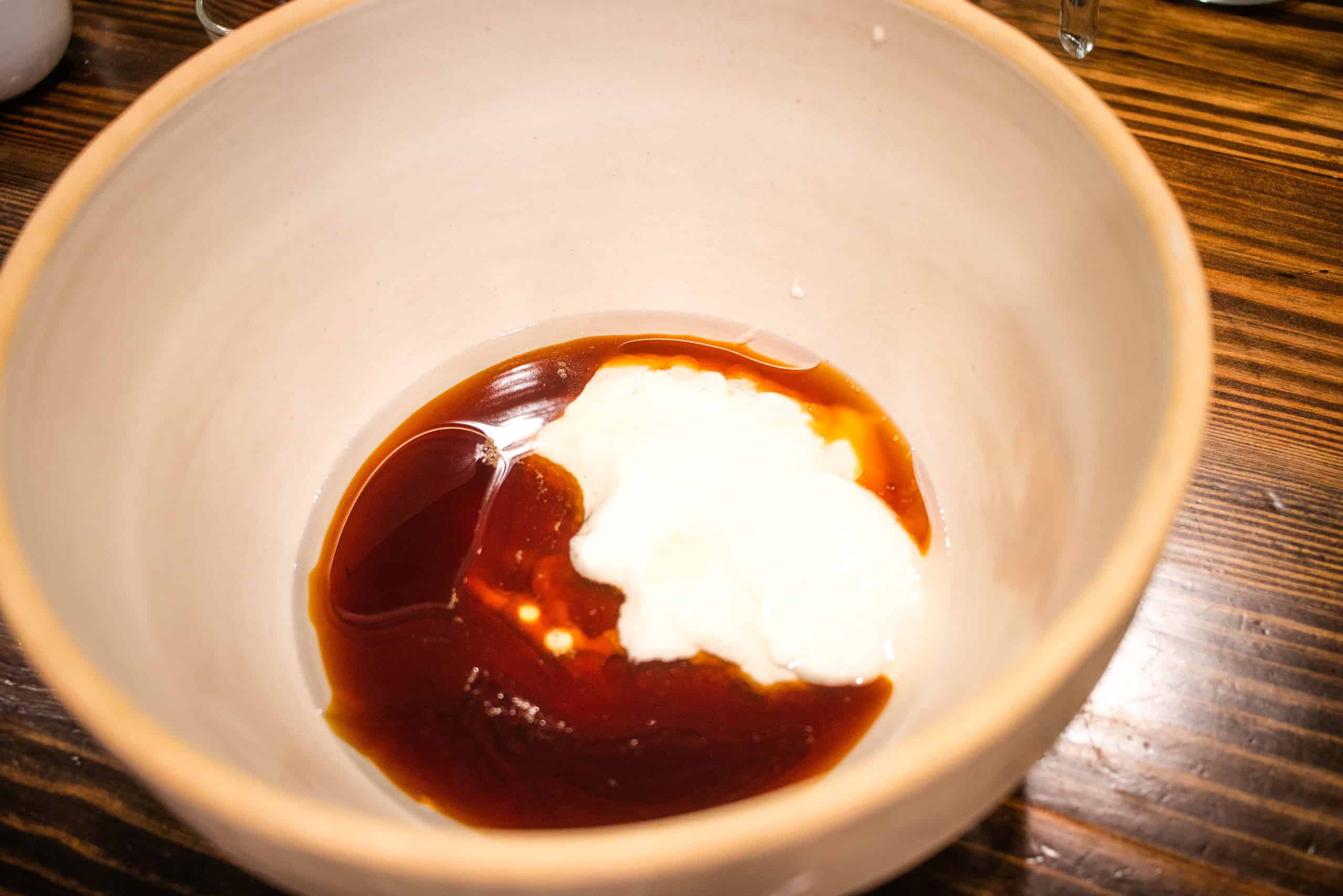 A large mixing bowl of coconut oil, maple syrup, and sourdough discard.