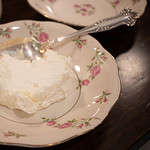 A small pink china bowl with a spoon and yogurt in the bowl.