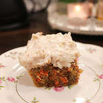 A slice of sourdough carrot cake on a pink floral china plate in a cottage kitchen.