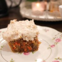 A slice of sourdough carrot cake on a pink floral china plate in a cottage kitchen.