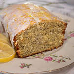 a loaf of lemon poppy seed poundcake on a pink floral china plate