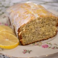 a loaf of lemon poppy seed poundcake on a pink floral china plate