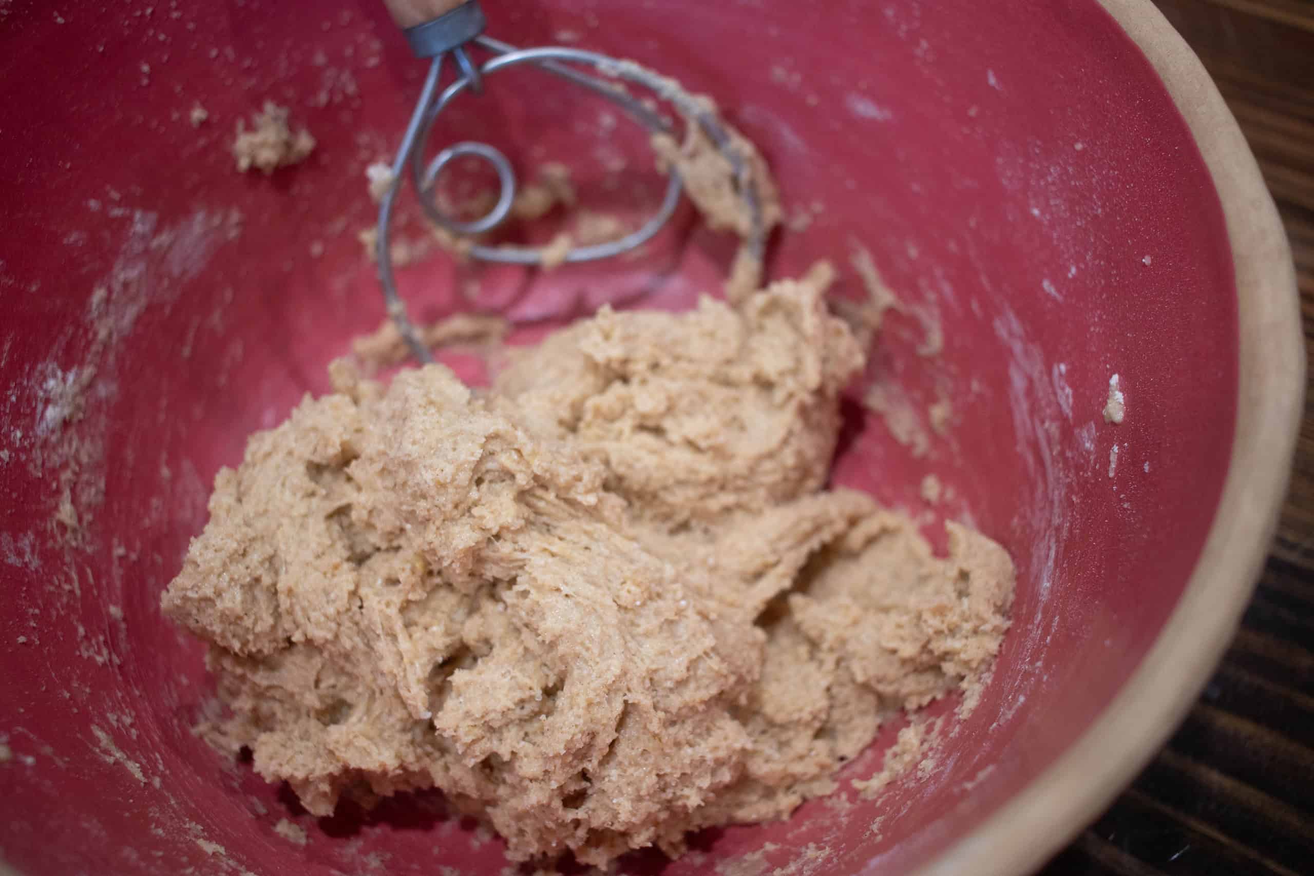 a mixture of dough for sourdough animal crackers in a pink ceramic bowl