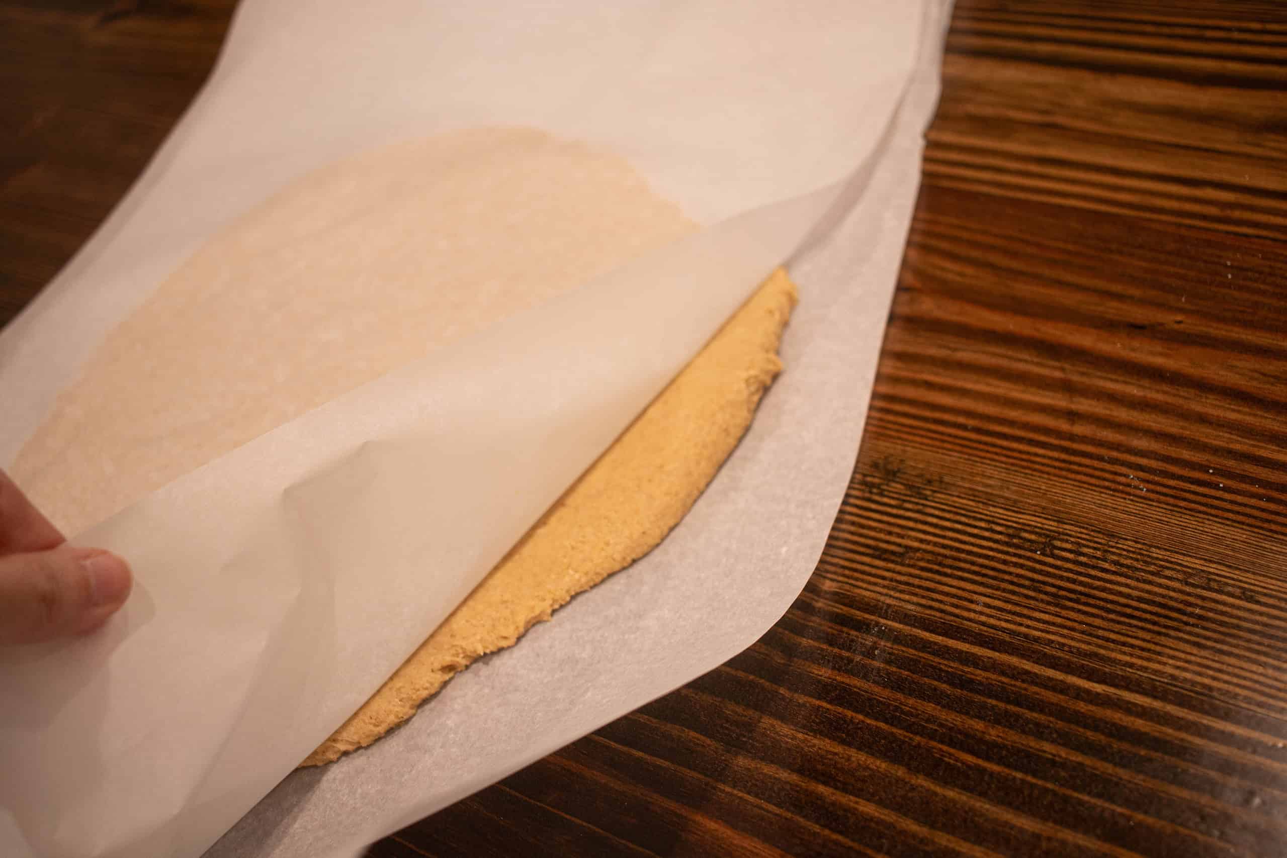 a woman showing the thickness of the dough for the sourdough animal crackers