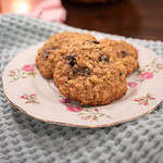 sourdough einkorn oatmeal raisin cookies on a pink rose china plate on a sage green dish towel