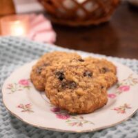 sourdough einkorn oatmeal raisin cookies on a pink rose china plate on a sage green dish towel