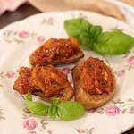 Three pieces of homemade bruschetta on a pink floral plate in a cottage kitchen.