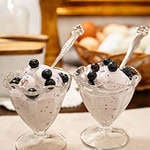 two glass ice cream serving bowls on a beige placemat in a cottage kitchen