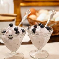 two glass ice cream serving bowls on a beige placemat in a cottage kitchen