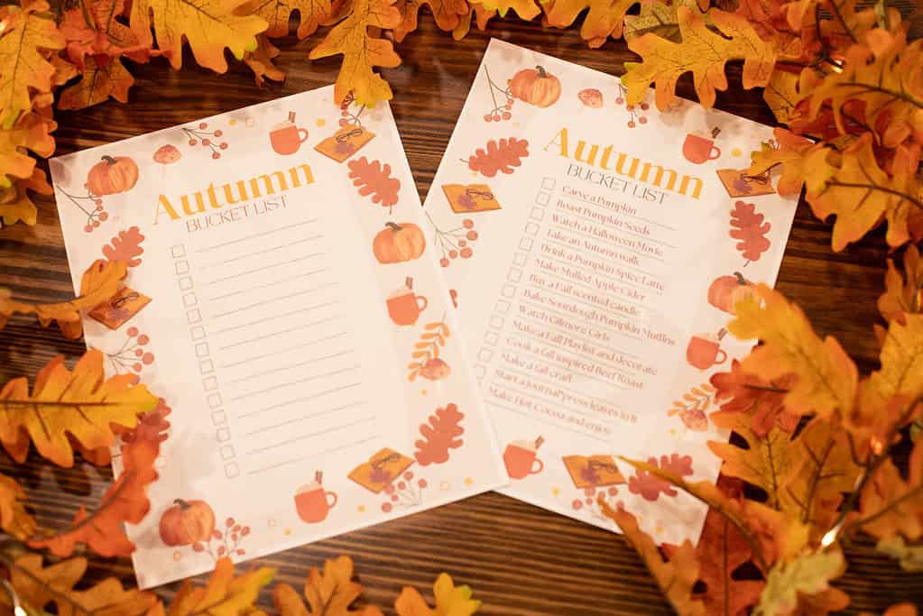 a picture of 2 the modern day cottages free printable autumn bucket list one blank and one filled out on a wooden counter top in a cozy cottage
