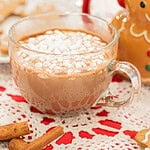 close up of gingerbread hot chocolate topped with mini marshmallows in glass mug