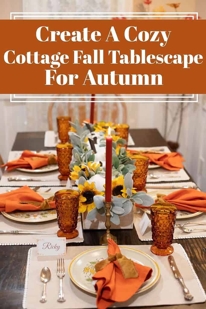A cozy cottage-style fall tablescape with amber glassware, sunflower centerpiece, and burnt-orange napkins tied with velvet ribbon. A candle glows warmly beside vintage dishes and personalized place cards, creating a welcoming autumn table setting.
