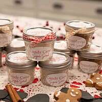 A closer angle of sugar scrub jars stacked and decorated for Christmas gifting, surrounded by cozy holiday accents.