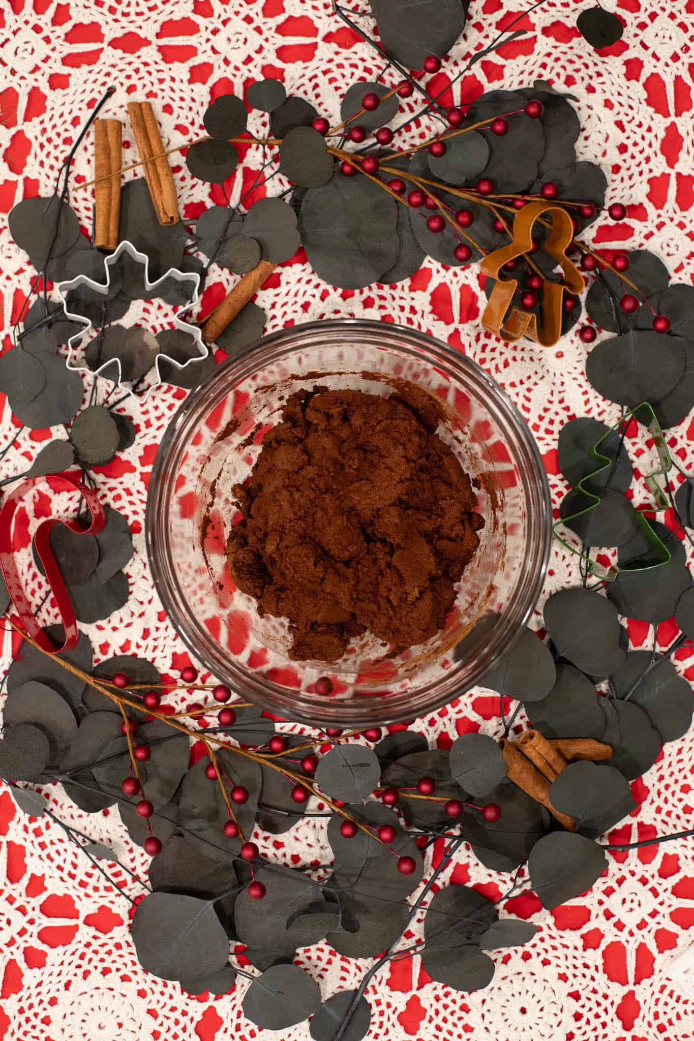 A bowl of cinnamon applesauce dough with ornament shapes and a rustic holiday aesthetic in the background.