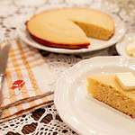 A slice of golden sourdough discard cornbread with butter melting on top, served on a white plate with a cozy backdrop.