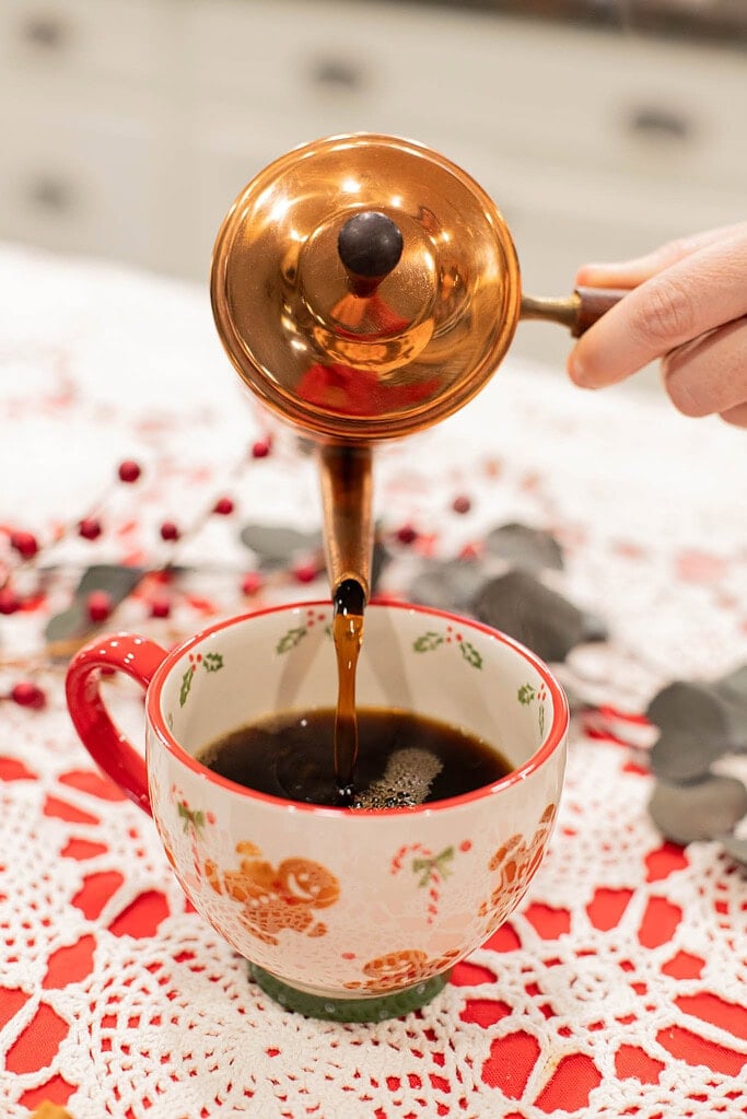 pouring brewed coffee into mug to make homemade gingerbread latte