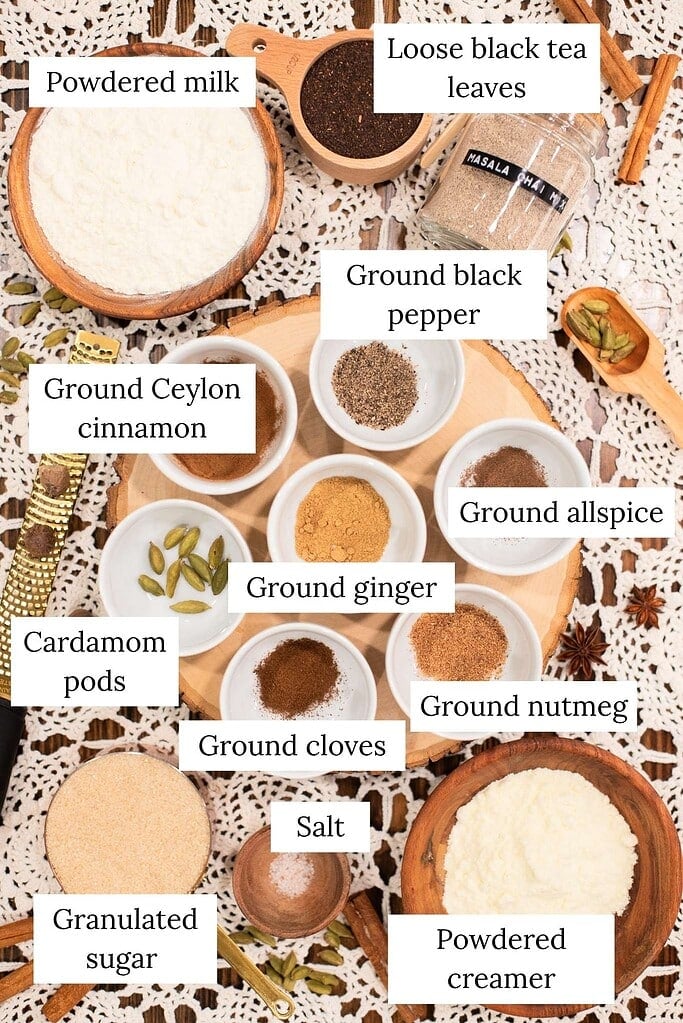 Ingredients for homemade spiced chai latte mix including black tea, cinnamon, ginger, cloves, cardamom, and powdered milk