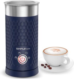 A navy blue electric milk frother with simple controls, shown beside a cappuccino topped with frothed milk and cinnamo