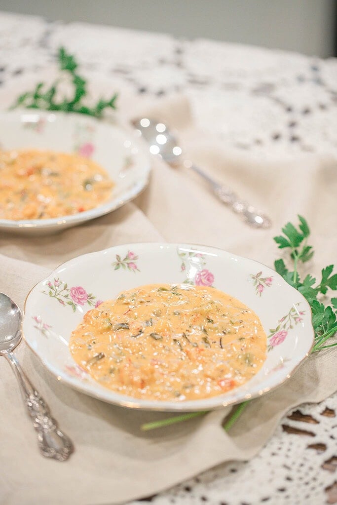 Overhead view of two bowls of crawfish and shrimp étouffée served with rice on a lace tablecloth