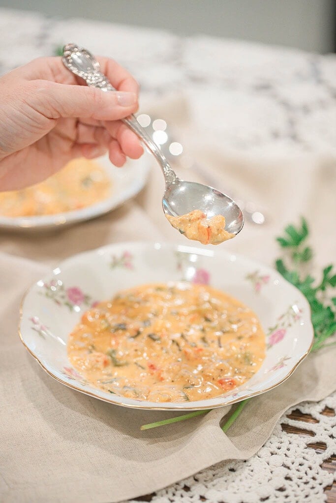 Spoon lifting a bite of creamy Cajun crawfish and shrimp étouffée with tender seafood and sauce