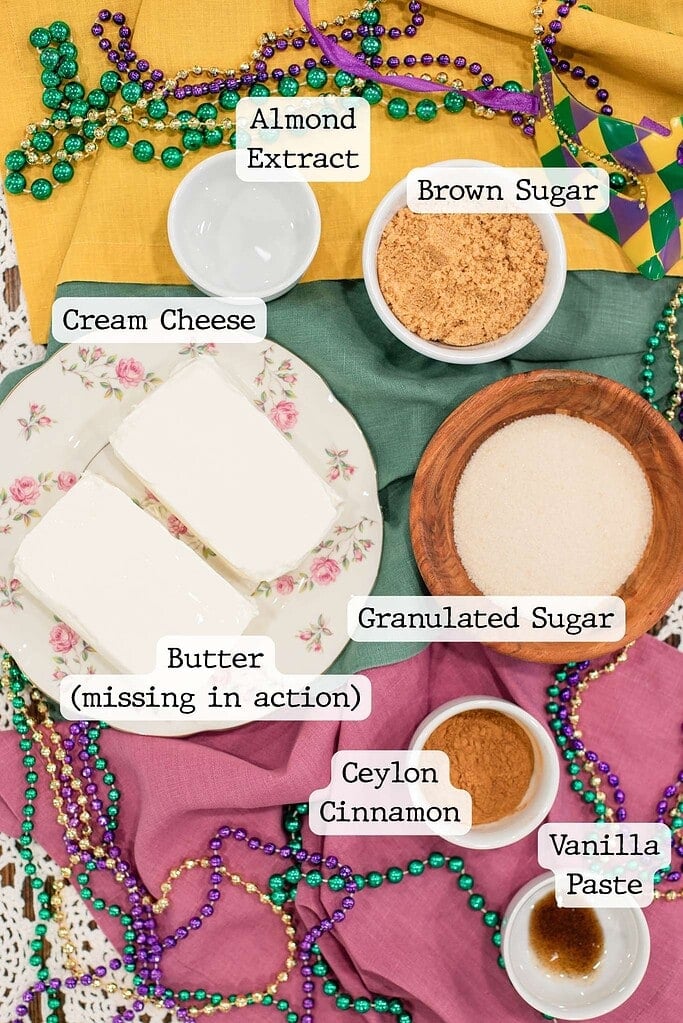 Flat lay of sourdough king cake filling ingredients including cream cheese, butter, brown sugar, cinnamon, vanilla, and almond extract
