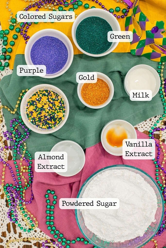 Bowls of purple, green, and gold colored sugar and sprinkles for decorating a Mardi Gras king cake