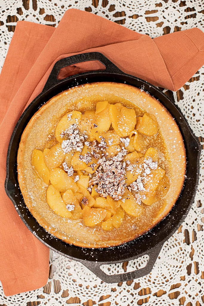 sourdough apple dutch baby pancake with caramel topping and powdered sugar