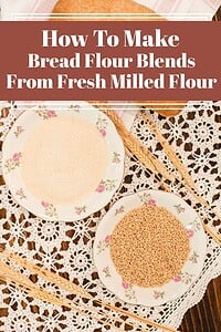 Freshly milled flour and wheat berries in vintage bowls on a lace tablecloth, illustrating how to make bread flour blends from fresh milled flour.