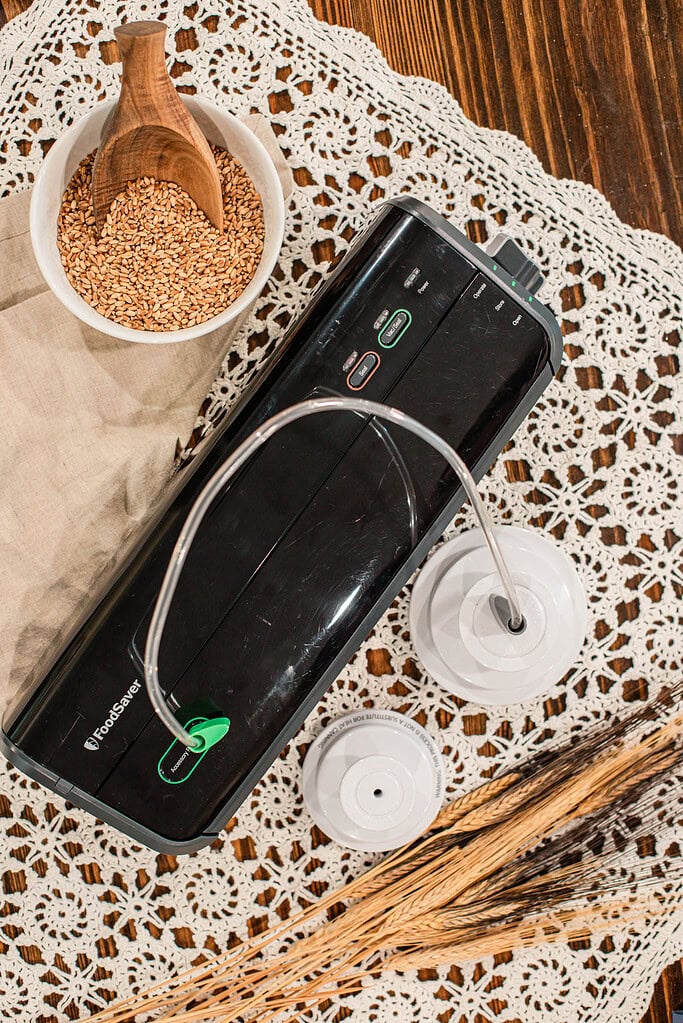 FoodSaver vacuum sealer with hose attachment and wheat berries on cottage table
