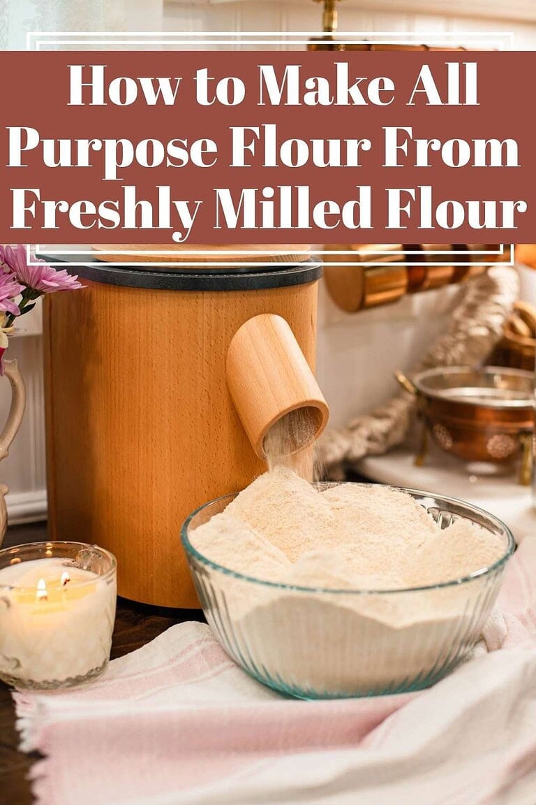 Freshly milled flour pouring from a wooden grain mill into a glass bowl on a cozy kitchen counter, with soft lighting, a candle, and text overlay reading “How to Make All Purpose Flour From Freshly Milled Flour”