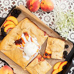 Sourdough peach blackberry galette with fresh milled flour topped with vanilla ice cream on baking tray