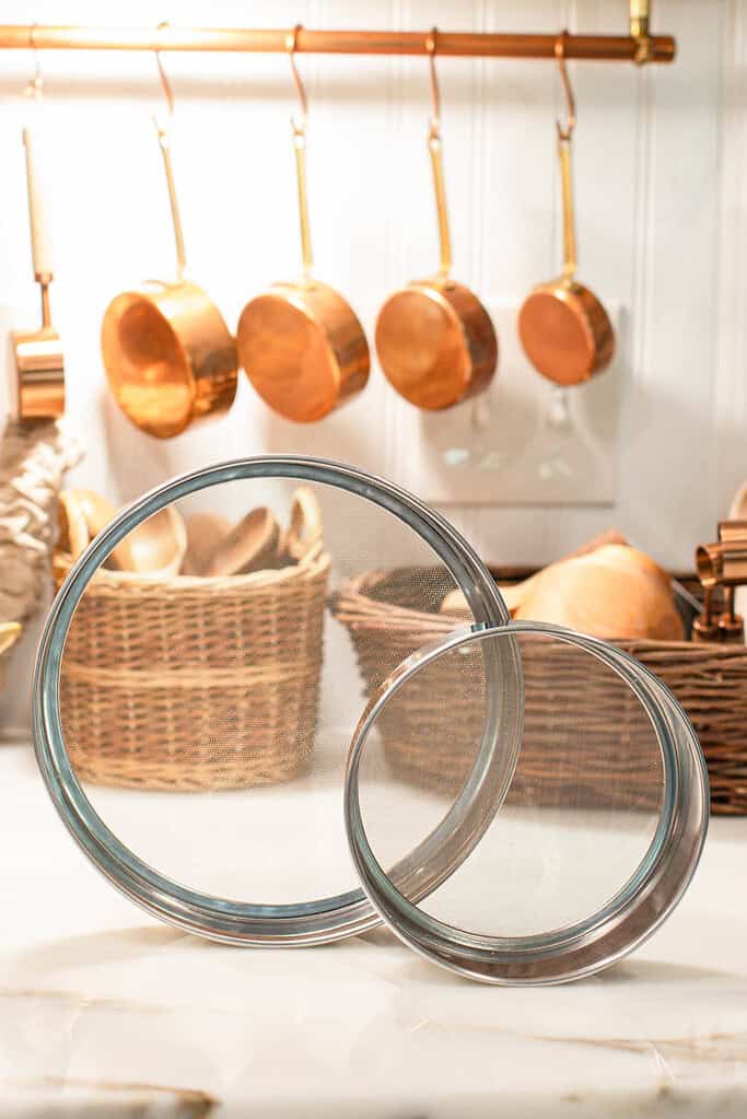 two manual sifters sitting on a marble countertop