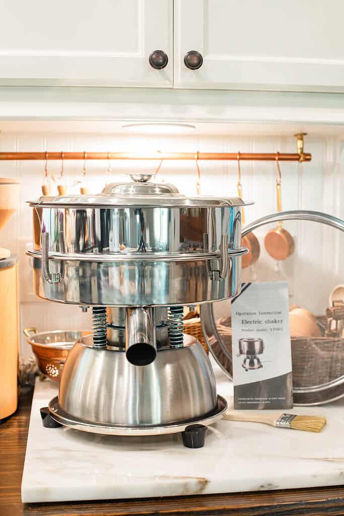 Stainless flour sifters lined up for home grain grinding.