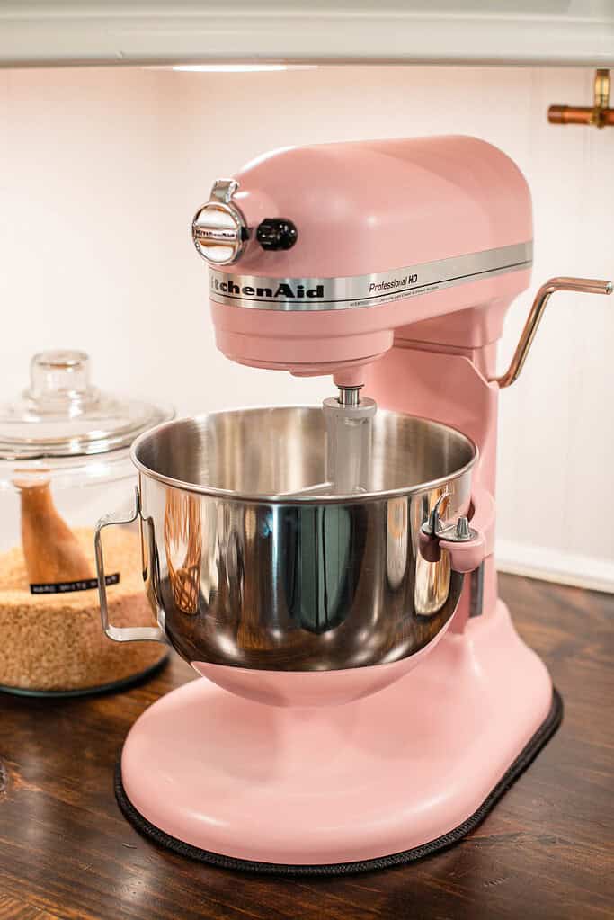 Pink stand mixer with stainless bowl ready for mixing dough.