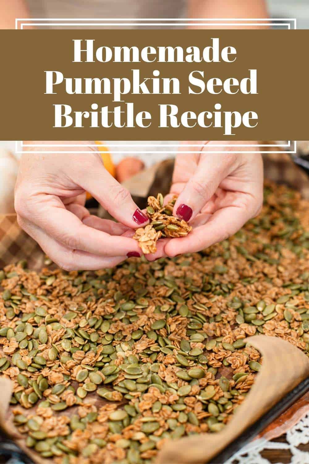 Hands breaking apart a golden cluster of homemade pumpkin seed brittle above a parchment-lined baking tray filled with roasted pumpkin seeds and oats. Text overlay reads: “Homemade Pumpkin Seed Brittle Recipe.”