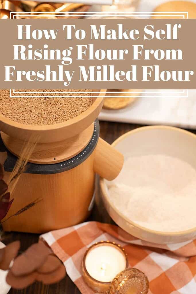 Wooden grain mill and bowl of flour on a warm autumn kitchen table with candles and checkered napkin, demonstrating how to make self-rising flour from freshly milled grains.