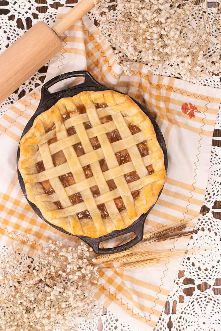 Golden brown lattice-top pie baked in a cast iron skillet with a flaky homemade pie crust.