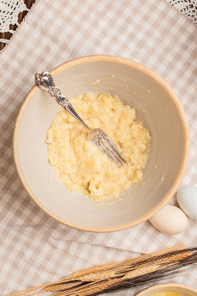 Mashing ripe bananas with a fork for banana muffins with freshly milled flour