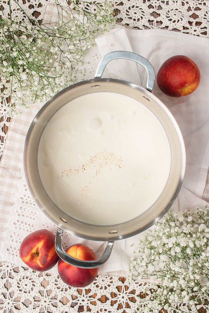 Cream mixture in a saucepan with vanilla bean flecks for homemade custard ice cream base