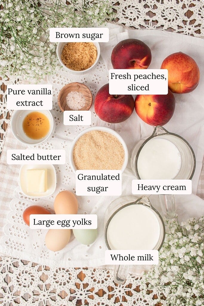 Flat lay of ingredients for brown butter peach custard ice cream including fresh peaches, heavy cream, whole milk, egg yolks, granulated sugar, brown sugar, butter, vanilla extract, and salt on a linen cloth.