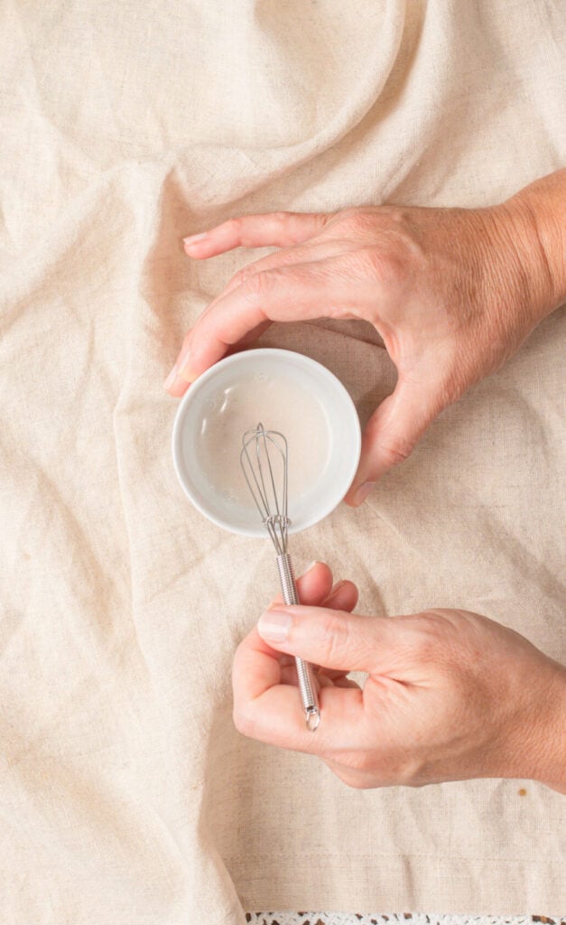 A small bowl of baking soda being whisked in preparation to add to brown butter sourdough chocolate chip cookie dough