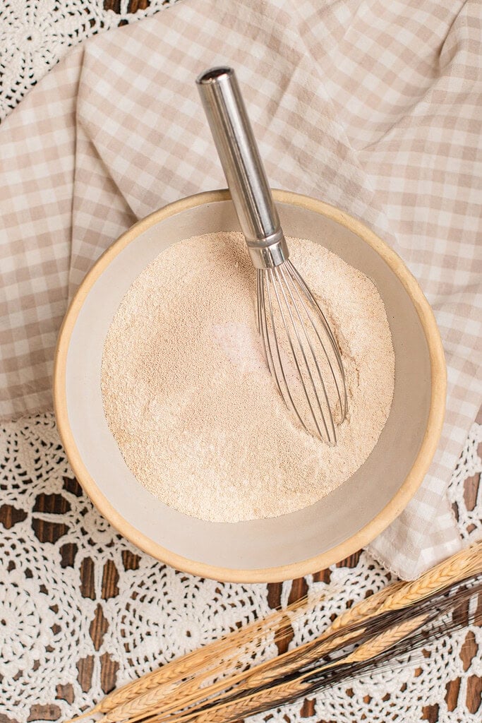 Whisking freshly milled flour and yeast together for homemade cinnamon rolls